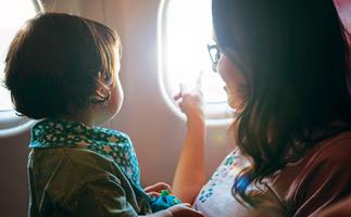 Mum and baby looking out window of plane