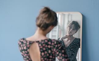 Indecisive woman looking in mirror