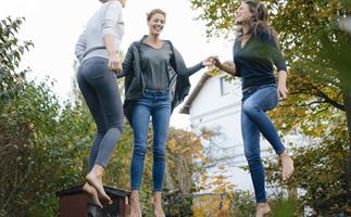 Three women bouncing on trmapoline