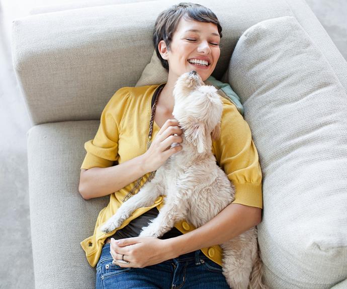 woman hugging a dog on her sofa