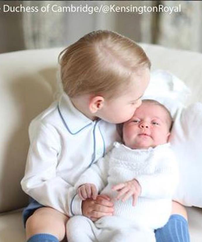 In another shot, the soon-to-be two-year-old plants a kiss on his sister's forehead