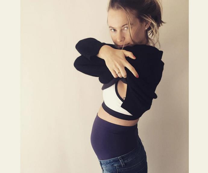 The model shows off her growing bump.